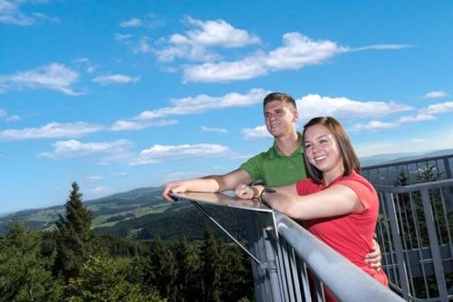 a man and a woman standing on top of a balcony at Ferienwohnung Familie Resch in Wegscheid