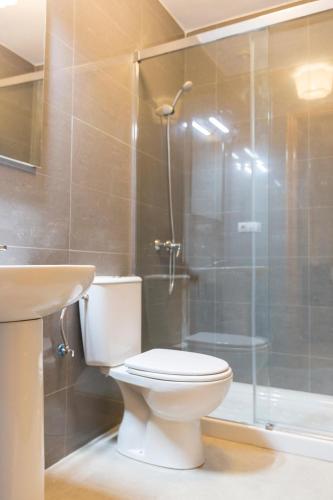 a bathroom with a toilet and a glass shower at Casita Las Malvinas en Villa de Nijar con piscina in Níjar