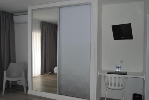 a mirror in a room with a table and a television at Estudiotel Alicante in Alicante