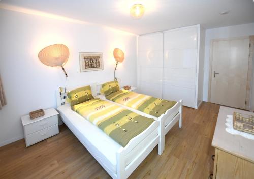 a bedroom with a white bed with yellow and green sheets at Haus Pyrola in Davos