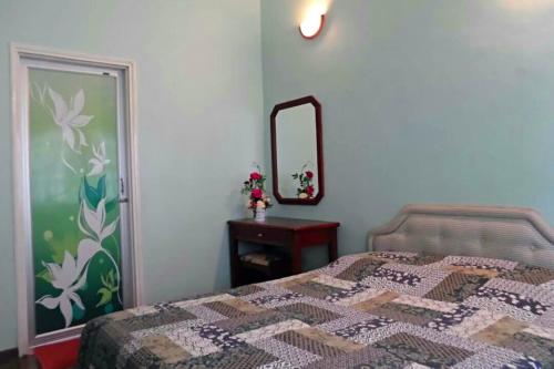 a bedroom with a bed and a mirror at 3 Rooms Apt@Greenhill Resort in Cameron Highlands