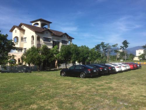 a row of cars parked in front of a building at Mallorca B&B in Taitung City