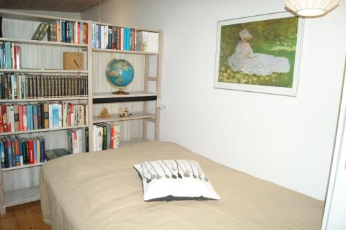 ein Schlafzimmer mit einem Bett und einem Bücherregal mit Büchern in der Unterkunft Glentevej 3 in Greve