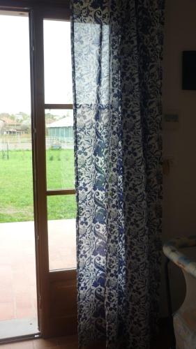 a door with a curtain next to a window at La Scuderia in Sarzana