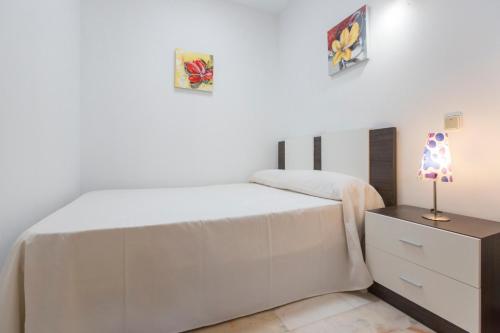 Habitación blanca con cama y mesita de noche en Casita Las Eras en Villa de Nijar con piscina, en Níjar