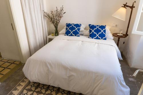 a bedroom with a large white bed with blue pillows at Blue Casita ETV 7845 in Pollença
