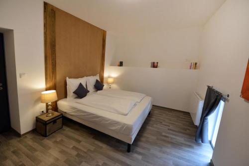 エギスハイムにあるGîte au château fleuriのウッドフロアのベッドルーム1室(ベッド1台、ランプ付)