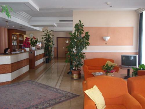 a lobby with orange chairs and a waiting room at Hotel Le Sorgenti in Bolzano Vicentino