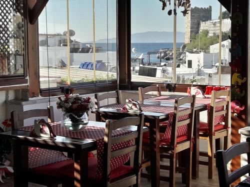 ボドルム・シティにあるMia Butik Hotel Bodrumのテーブルと椅子が備わり、海の景色を望むレストラン
