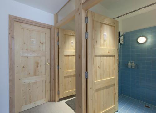 a bathroom with wooden doors and blue tiles at Pinto Hostel in Bangkok