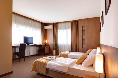 ein Hotelzimmer mit 2 Betten und einem Schreibtisch in der Unterkunft Hotel Knezevina in Vranic