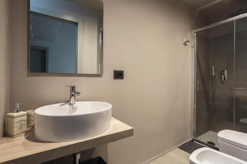 ボローニャにあるSant'Orsola Suites Apartmentsの白い洗面台とシャワー付きのバスルーム