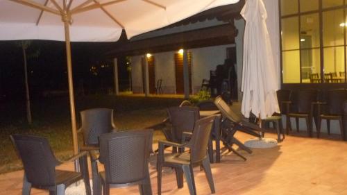 a group of chairs and a table with an umbrella at La Scuderia in Sarzana