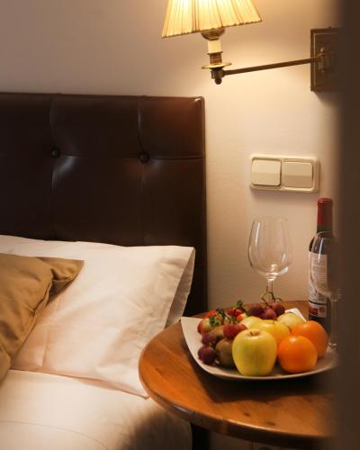 a plate of fruit on a table next to a bed at Hotel Cuéntame La Puebla in Burgos