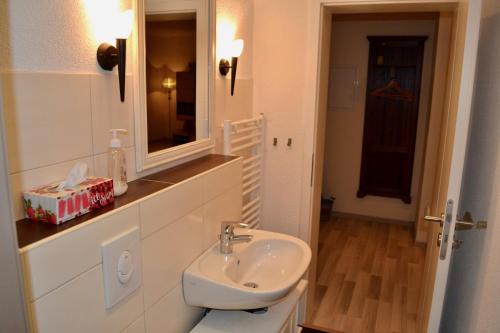 Baño blanco con lavabo y espejo en Ferienwohnung Holland 5a en Lügde