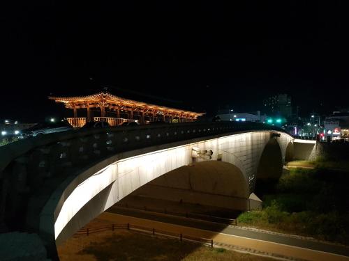 a bridge with a chinese building on top of it at night at Hanok Hyeyum in Jeonju