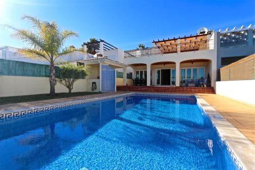 a swimming pool in front of a house at Villa Heloise 139 - Clever Details in Vilamoura
