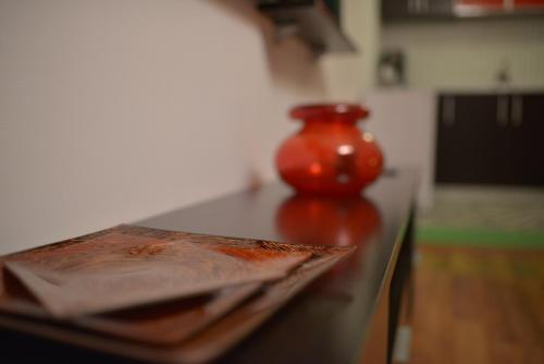 a red vase sitting on top of a table at Vila Sia in Bucharest