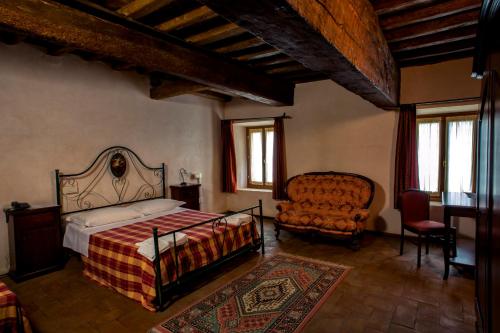 ein Schlafzimmer mit einem Bett und einem Stuhl in der Unterkunft Hotel La Corte in Correzzola