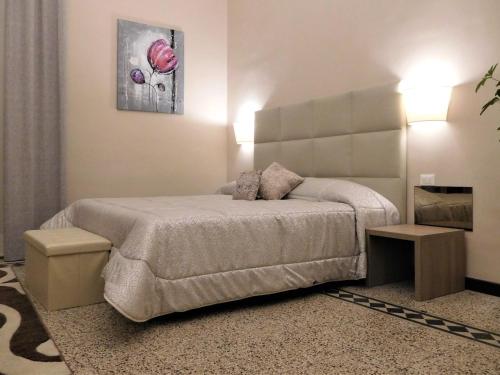 a bedroom with a large bed and two tables at Hotel Etnea Royal Suites in Catania