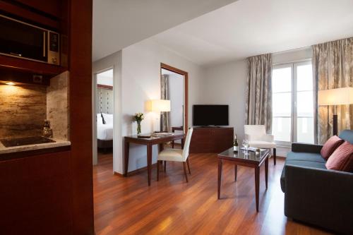 a living room with a couch and a room with a tv at Relais Spa Val d'Europe in Chessy