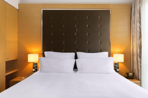a bedroom with a large bed with two white pillows at Relais Spa Val d'Europe in Chessy