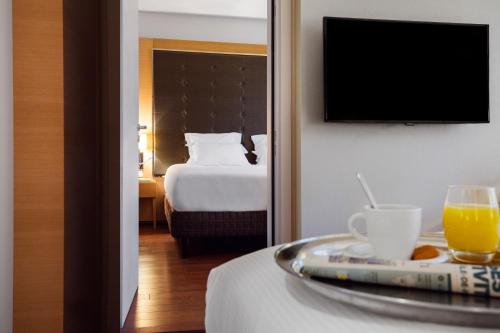 a hotel room with a tray of orange juice and a bed at Relais Spa Val d'Europe in Chessy