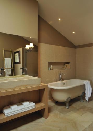 une grande salle de bain avec une baignoire et un lavabo dans l'établissement Domaine de la Soucherie - Chambres d'hôtes, à Beaulieu-sur-Layon