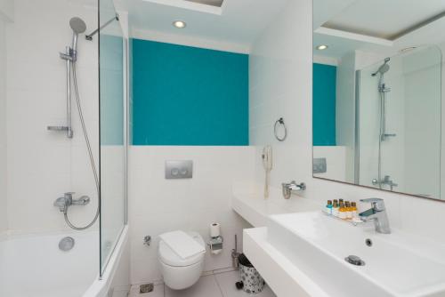 a bathroom with a toilet and a shower and a sink at Bendis Beach Hotel in Akyarlar