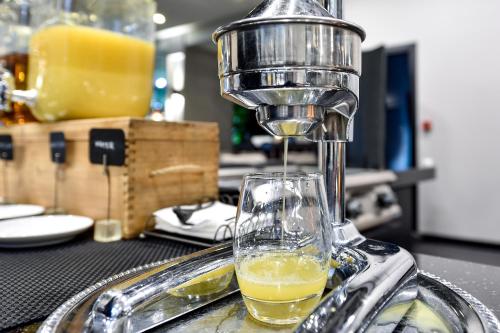 a drink is being poured into a glass at Amberton Cathedral Square Hotel Vilnius in Vilnius