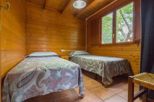 1 dormitorio con 2 camas en una cabaña de madera en El Mas de Xetà en Luchente