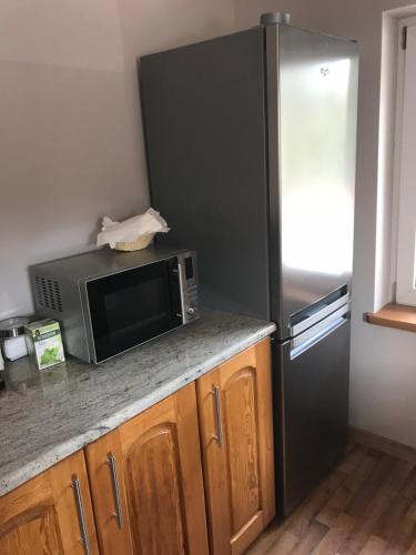 a kitchen with a microwave and a refrigerator at Podgórzanka in Kaczorów