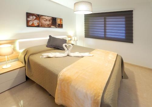 a bedroom with a bed with a swan on it at La Perla: Sea View and Pool (family apartment) in El Médano