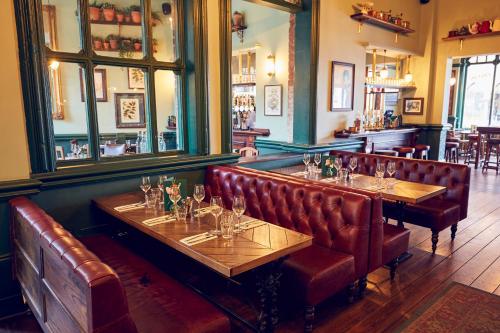 a restaurant with brown leather seats and a bar at The Old Coffee Tavern in Warwick