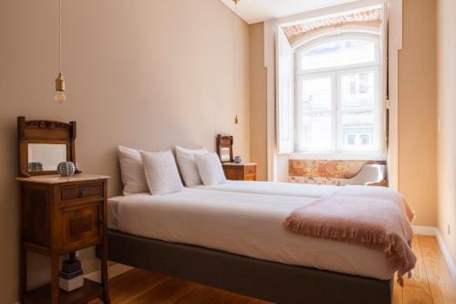 a bedroom with a large bed and a window at Alfama Baixa Spacious And Bright Apartment Blends the Historic and the Contemporary 2 Bedrs & 2 Bathrs AC 18th Century Building in Lisbon
