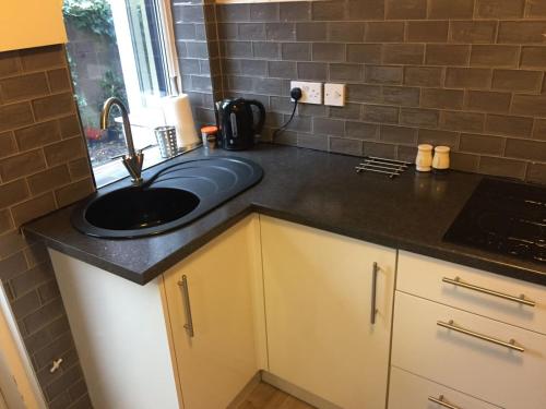 a kitchen with a sink and a counter top at Cosy Apartment in Private Courtyard in Preston