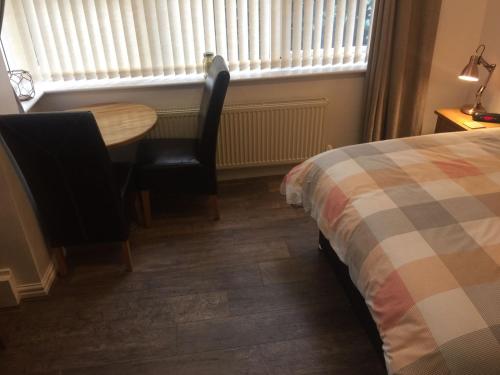 - une chambre avec une table, des chaises et un lit dans l'établissement Cosy Apartment in Private Courtyard, à Preston