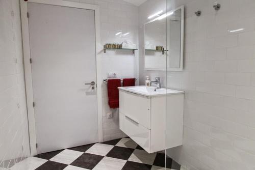 a white bathroom with a sink and a mirror at Clos Figueras in Gratallops