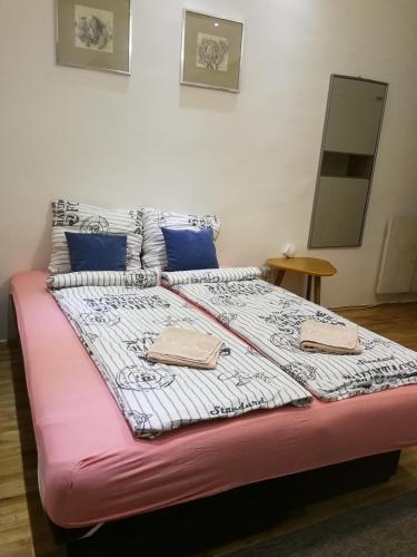 a large bed with a pink and white comforter at Imperia Apartments in Belgrade
