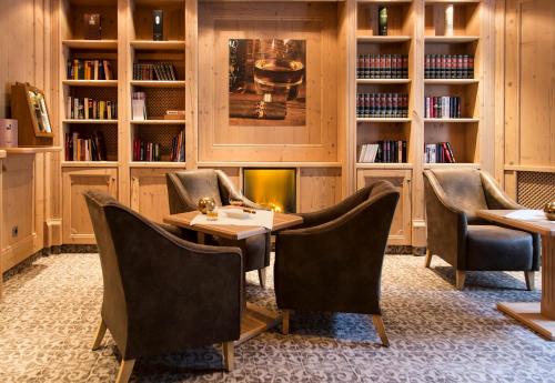 a restaurant with chairs and a table and a fireplace at Hotel Edelweiss Hochsölden Superior in Sölden