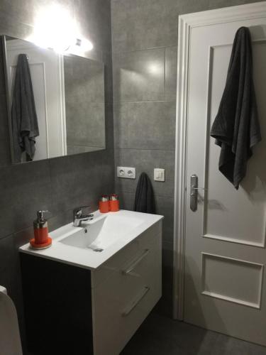 La salle de bains est pourvue d'un lavabo blanc et d'un miroir. dans l'établissement 8 Beach Villas Casa Tomas, à Caleta de Fuste