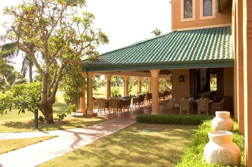a patio with tables and chairs on a house at Avani Pemba Beach Hotel in Pemba