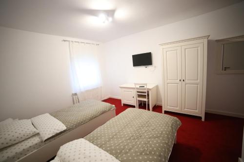 a bedroom with two beds and a desk and a tv at Fresh Accommodation in Rădăuţi