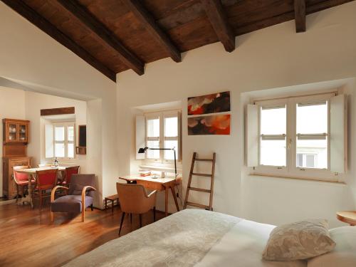 a bedroom with a bed and a table and chairs at Boutique Hotel Albero Nascosto in Trieste