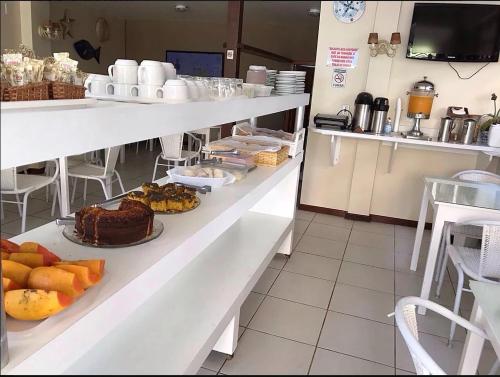 a bakery with a table with food on it at Pousada Alice in Cabo Frio