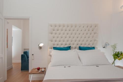 a bedroom with a large white bed with blue pillows at Dimora Degli Dei in Rome