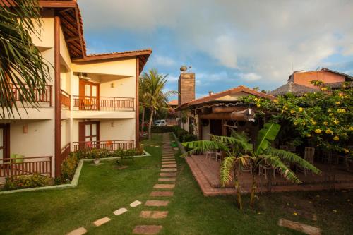 una casa con un patio de césped al lado de un edificio en Kanaloa Pousada, en Jericoacoara
