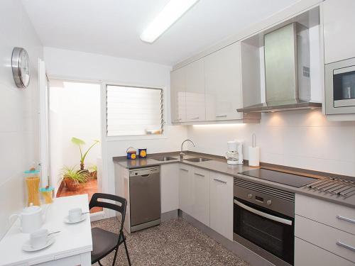 cocina con armarios blancos y fogones en Apartment Sant Pol by Interhome, en Sant Pol de Mar