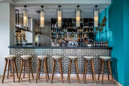 a bar with stools in front of a counter at Happy Cretan Suites in Agia Pelagia
