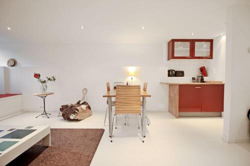 ein Wohnzimmer mit einem Tisch und einer Küche in der Unterkunft Romantic Jordaan Canalsuite near Anne Frank House in Amsterdam